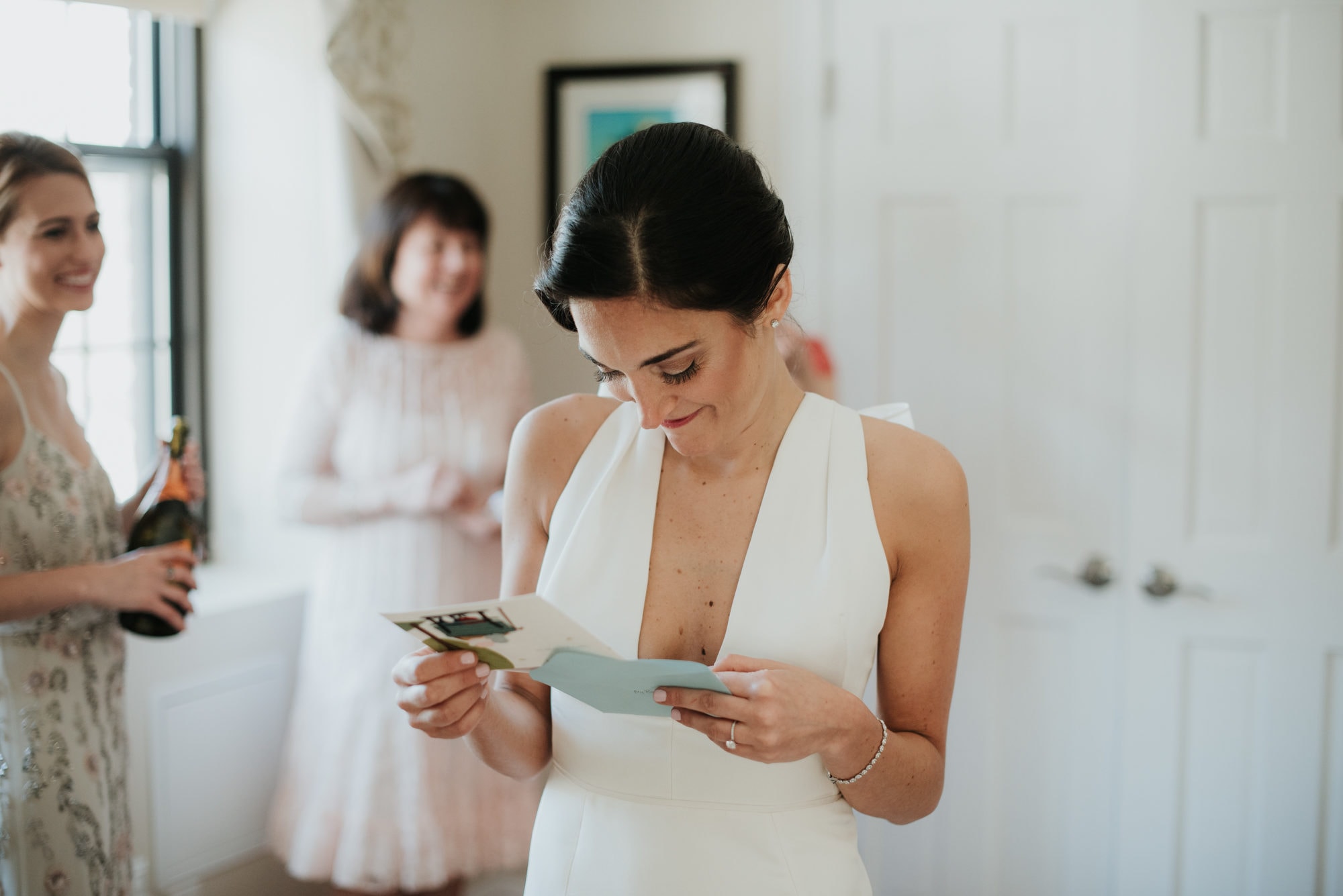 Bride reading card in Marchesa Gown
